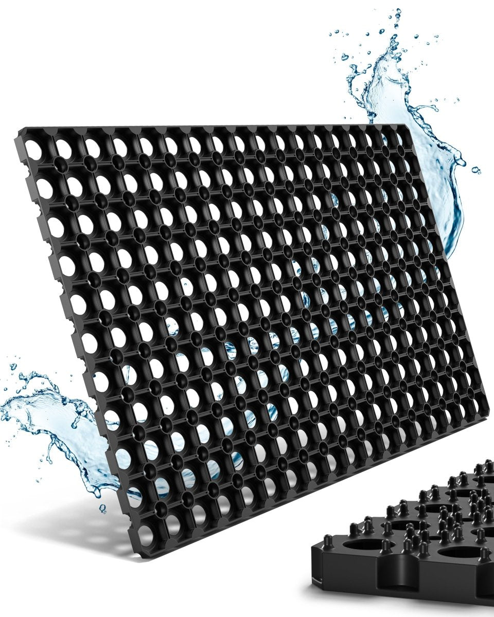 Schwarze Gummi-Fußmatte für außen mit Ringöffnungen, Detail der genoppten Unterseite und Wasserspritzern