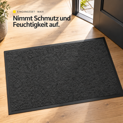 Die anthrazitfarbene Innenmatte des Maxi-Sets nimmt Schmutz und Feuchtigkeit auf. Darstellung hinter der geöffneten Haustür.